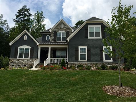 grey metal house with green roof|black roof with gray siding.